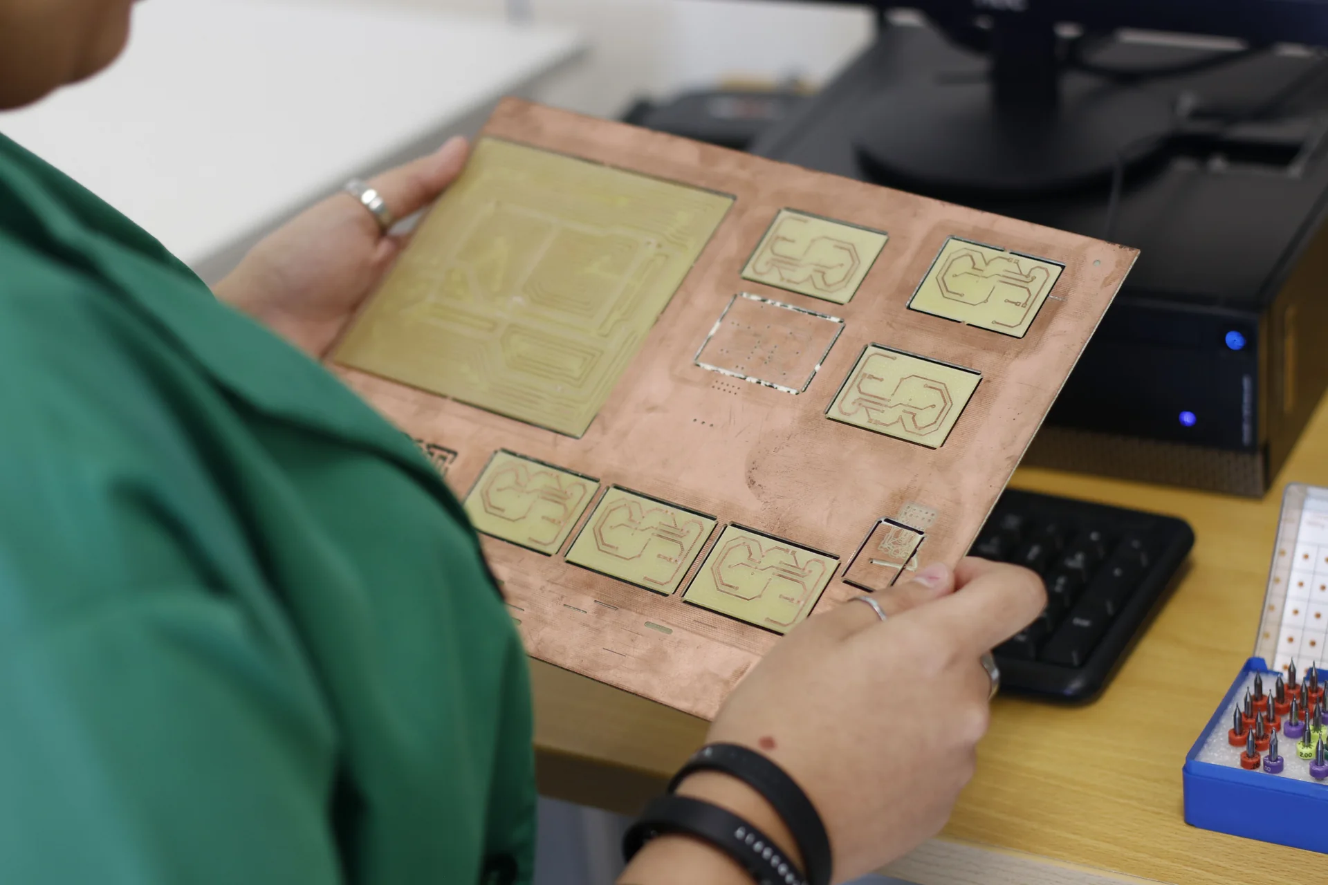 Technician examining a printed circuit board in an electronics lab